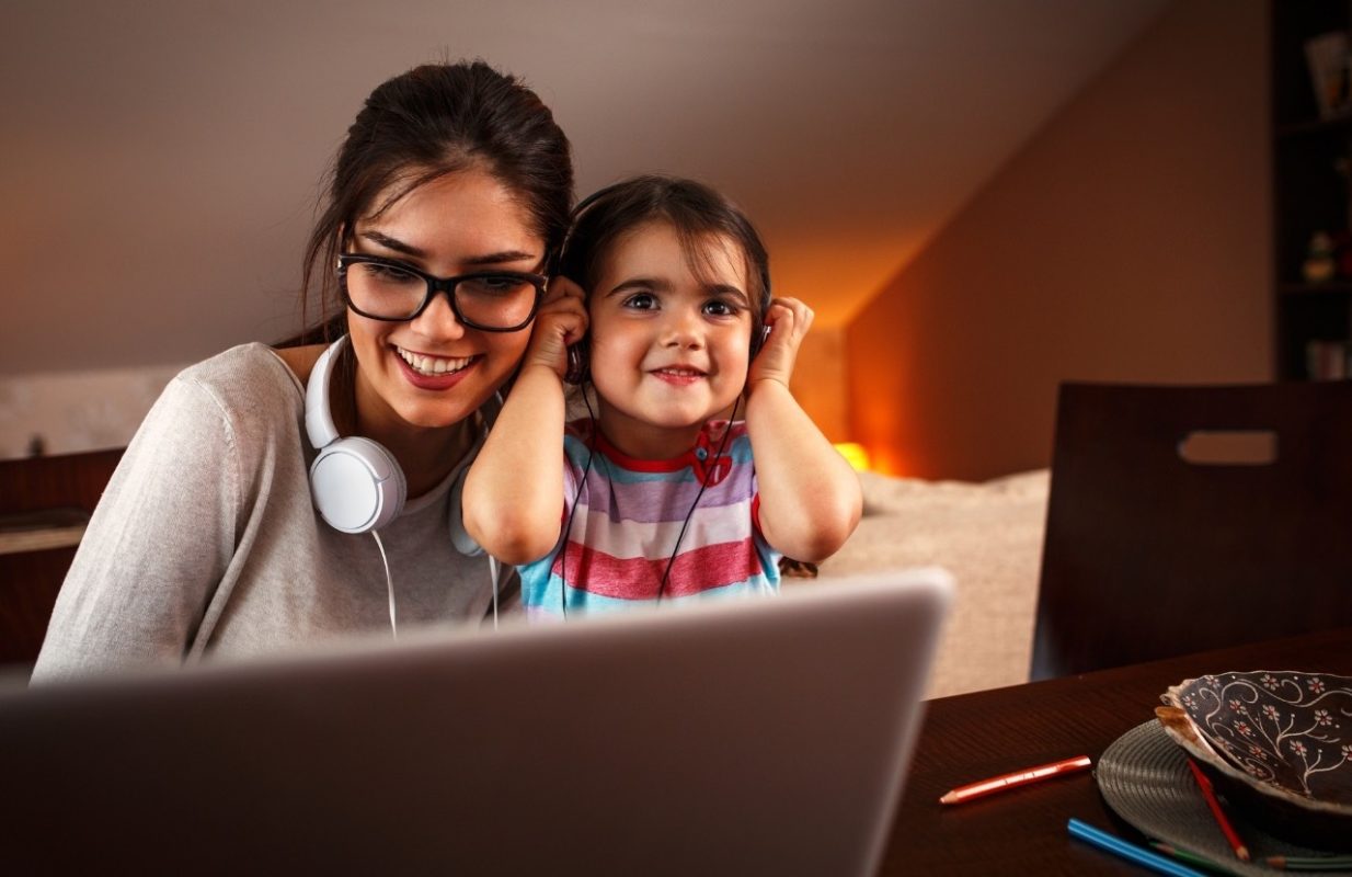 madre e hija disfrutando de la música frente al ordenador